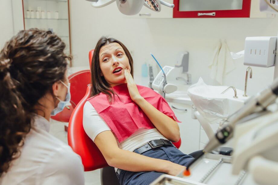 young girl with tooth pain at dentist