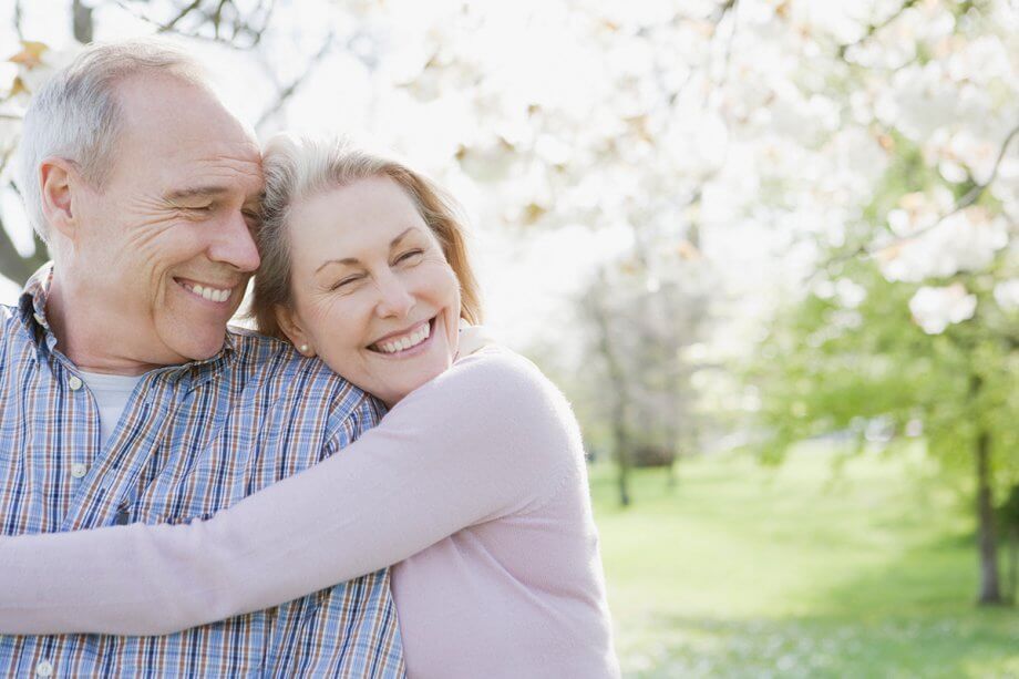 Happy older couple hugging outdoors