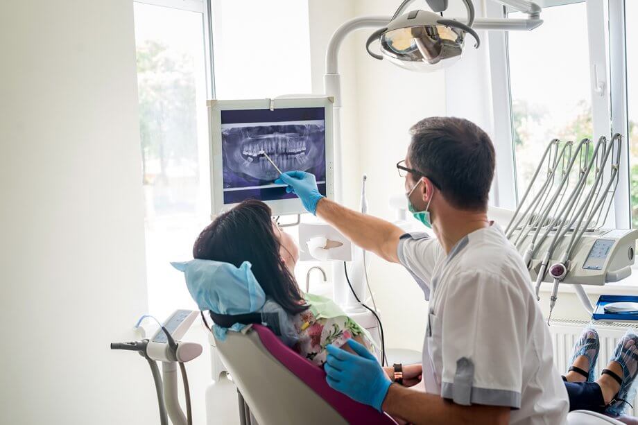 periodontist showing dental implant on x-ray